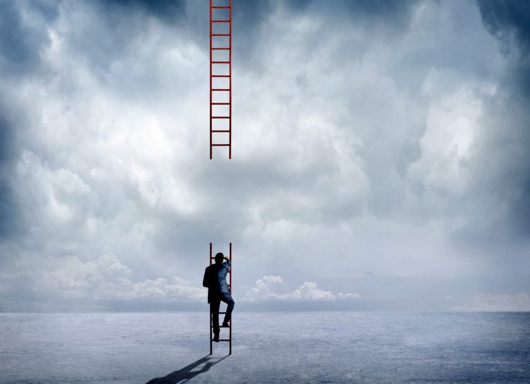 A businessman attempts to climb a large red ladder that has a big missing segment that will prevent him from reaching his destination.